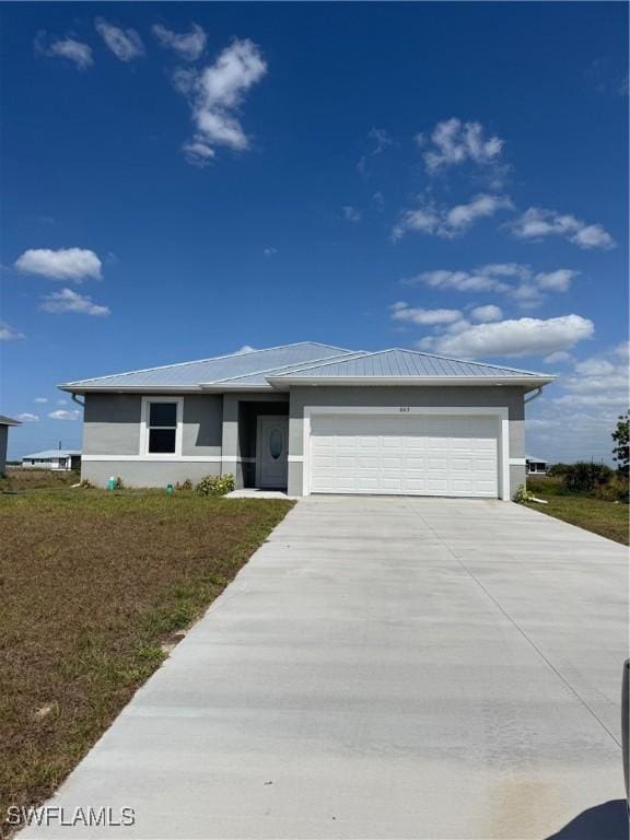 603 Marcella Ter, Labelle, FL 33935 - prairie-style house with driveway, stucco siding, an attached garage, and metal roof