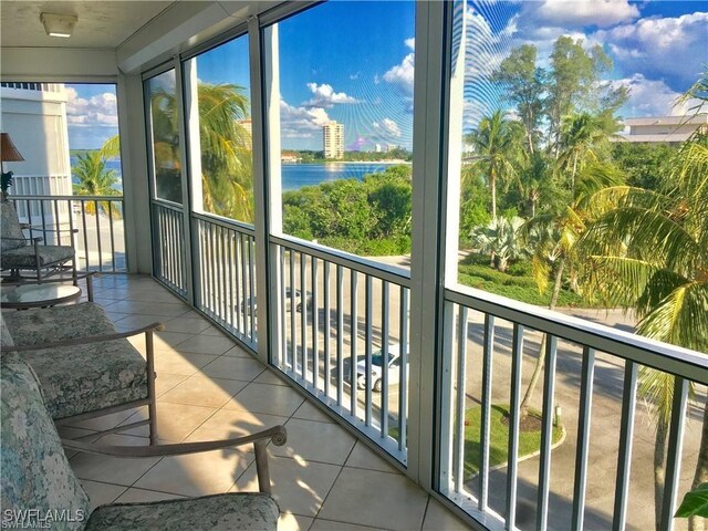 sunroom featuring a water view