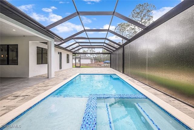 view of pool with a patio area and glass enclosure