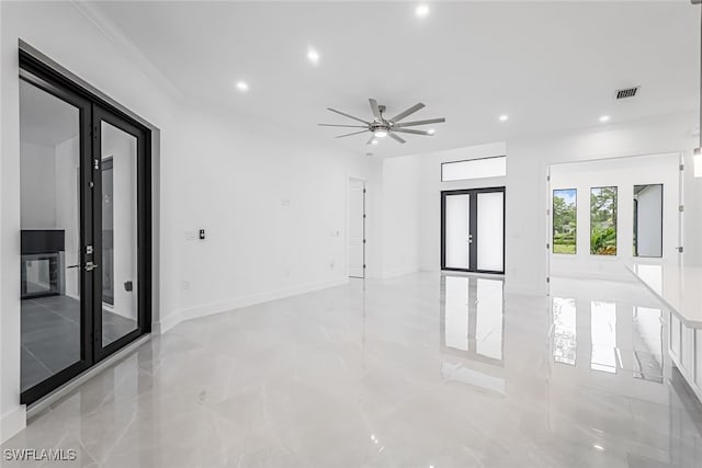 tiled spare room featuring ceiling fan, ornamental molding, and french doors