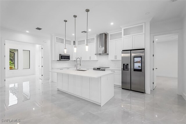 kitchen featuring appliances with stainless steel finishes, sink, a center island with sink, wall chimney range hood, and white cabinets