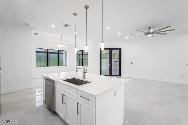 kitchen with sink, an island with sink, dishwasher, ceiling fan, and pendant lighting