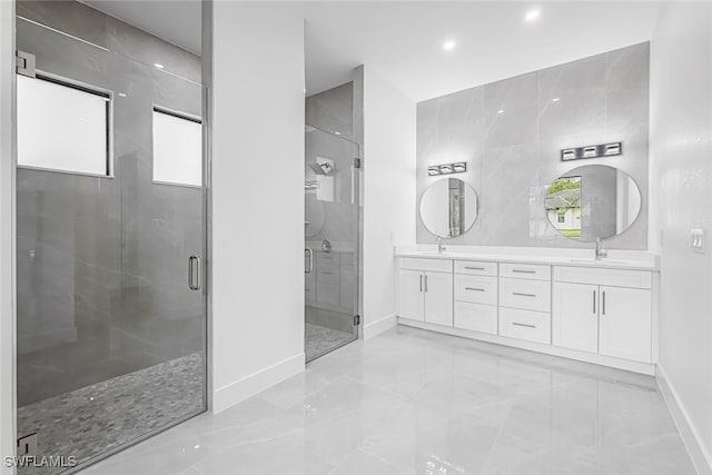 bathroom with tile walls, tile patterned flooring, double sink vanity, and a shower with shower door