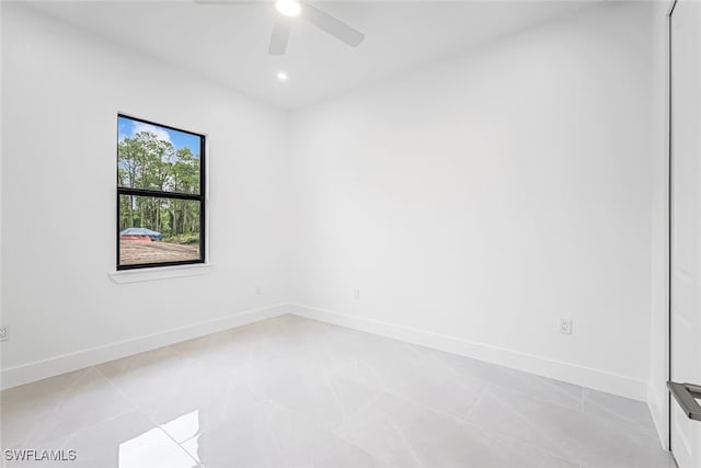 tiled spare room with ceiling fan