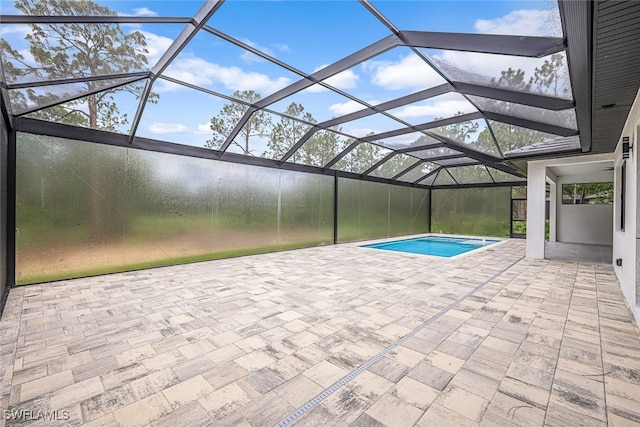 view of pool with glass enclosure and a patio area