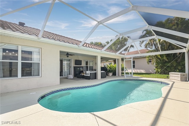 outdoor pool featuring an outdoor hangout area, ceiling fan, a patio, and glass enclosure