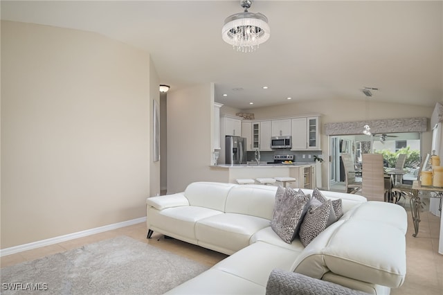 tiled living room with sink, lofted ceiling, and a chandelier