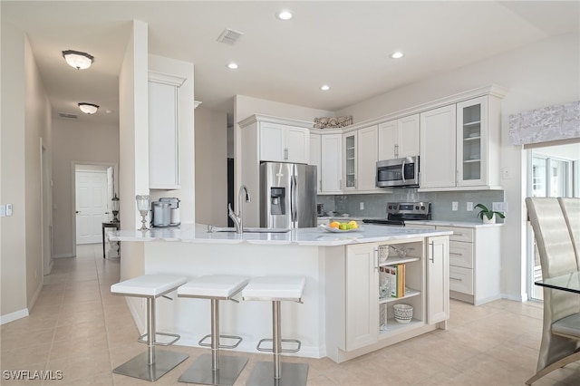 kitchen with white cabinetry, glass insert cabinets, and stainless steel appliances