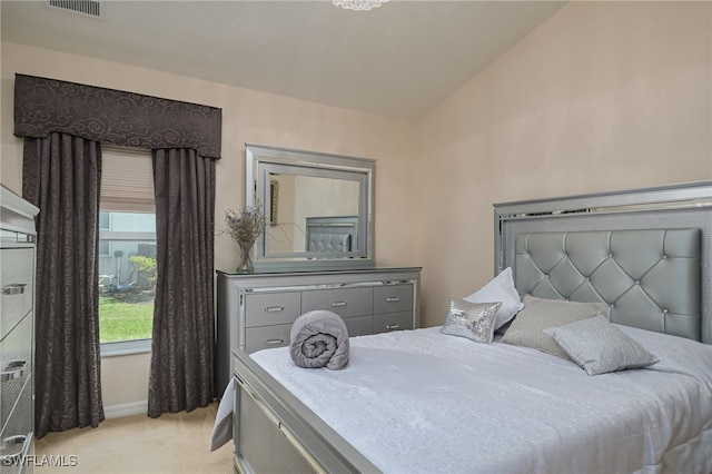 bedroom featuring lofted ceiling, light carpet, and visible vents