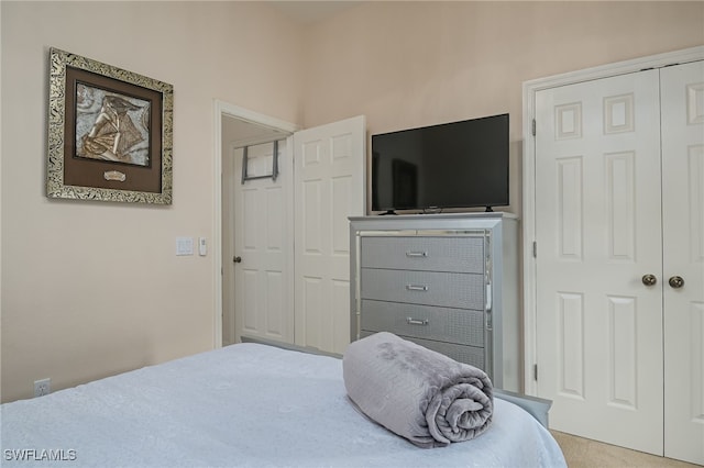 bedroom with light carpet and a closet