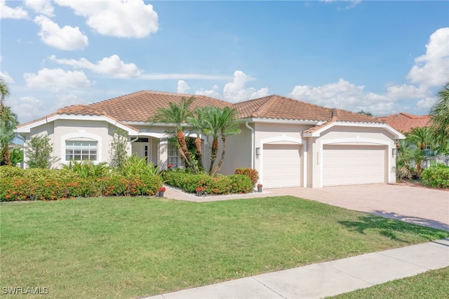 mediterranean / spanish home featuring a garage, a tile roof, and a front lawn