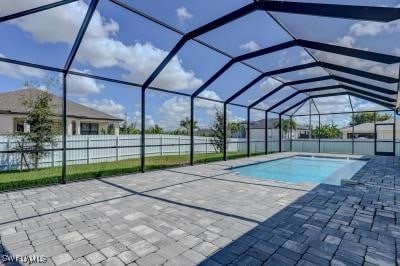 view of pool with a patio and glass enclosure