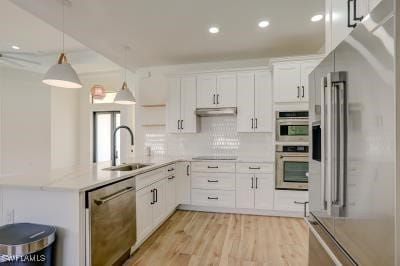 kitchen with pendant lighting, sink, white cabinetry, appliances with stainless steel finishes, and light hardwood / wood-style floors