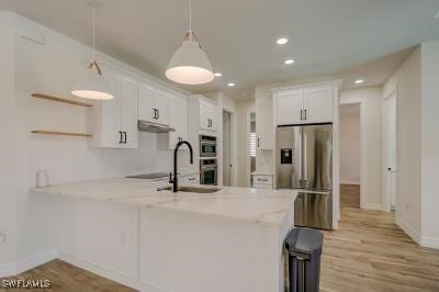 kitchen with white cabinets, light hardwood / wood-style flooring, kitchen peninsula, and decorative light fixtures