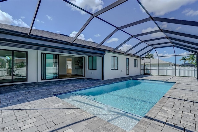 view of swimming pool with glass enclosure and a patio