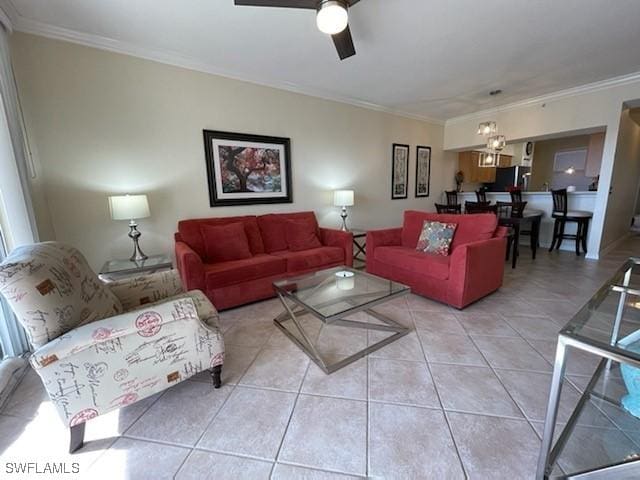 living room with a ceiling fan, crown molding, and light tile patterned floors