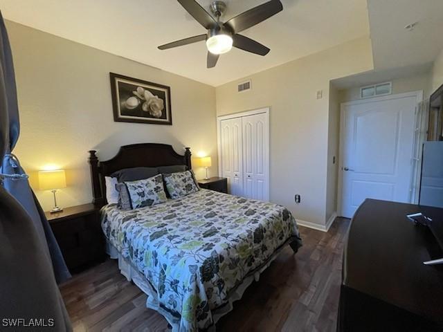 bedroom with dark wood-type flooring, visible vents, a ceiling fan, baseboards, and a closet