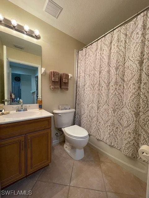 bathroom with a textured ceiling, toilet, vanity, visible vents, and tile patterned floors