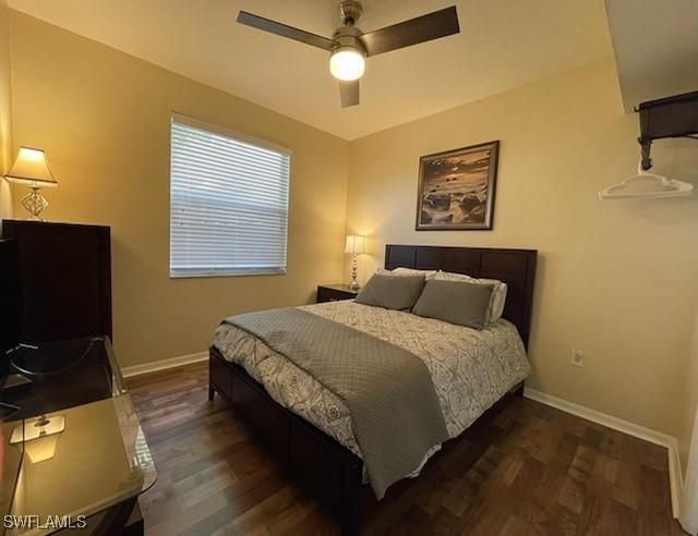 bedroom featuring dark wood-type flooring, ceiling fan, and baseboards