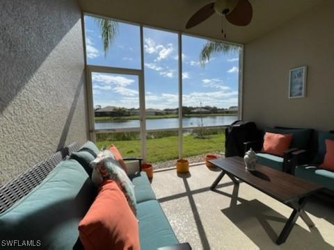 sunroom / solarium featuring ceiling fan and a water view