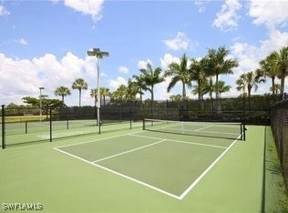 view of tennis court with community basketball court and fence