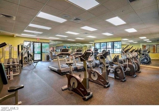 exercise room with visible vents and a paneled ceiling