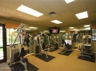 exercise room featuring carpet floors, a paneled ceiling, and visible vents