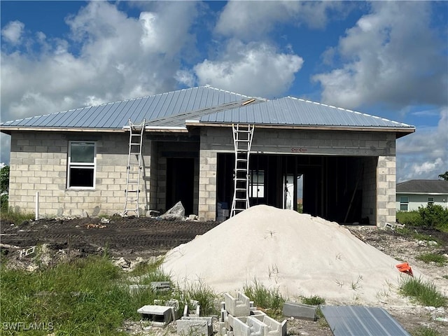 exterior space featuring concrete block siding and metal roof