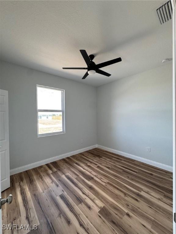 unfurnished room featuring visible vents, ceiling fan, wood finished floors, and baseboards