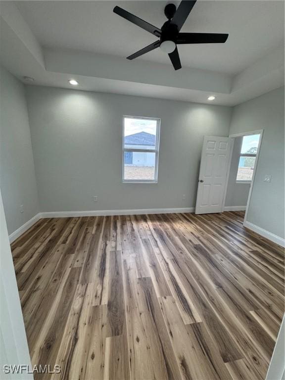 unfurnished room featuring recessed lighting, ceiling fan, wood finished floors, and baseboards