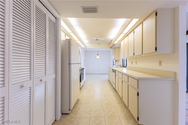 kitchen featuring ceiling fan, hanging light fixtures, stainless steel stove, white fridge, and light tile patterned floors