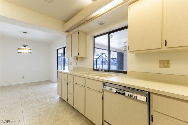 kitchen featuring pendant lighting, cream cabinets, white dishwasher, sink, and light tile patterned floors