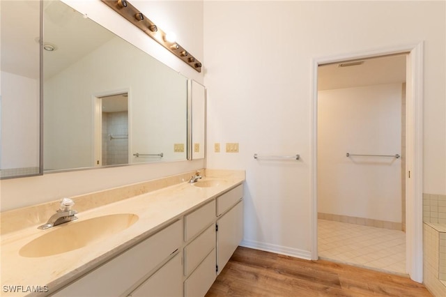 bathroom with vanity, lofted ceiling, and hardwood / wood-style flooring