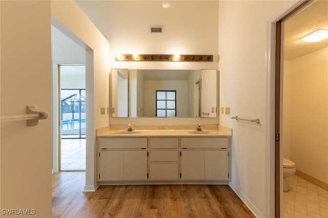 bathroom with wood-type flooring, vanity, and toilet