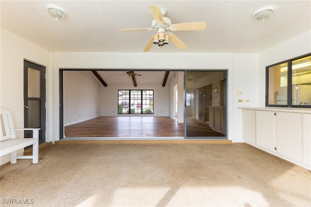 unfurnished room featuring wood-type flooring, lofted ceiling with beams, and ceiling fan