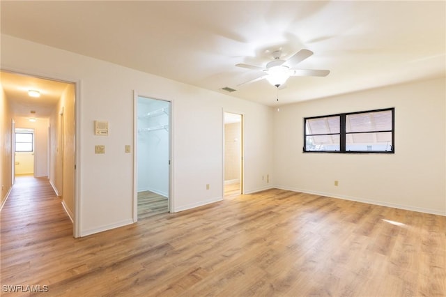 interior space with a spacious closet, a closet, ceiling fan, and light hardwood / wood-style floors