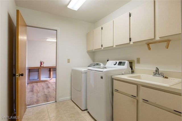 laundry room with cabinets, independent washer and dryer, light wood-type flooring, and sink