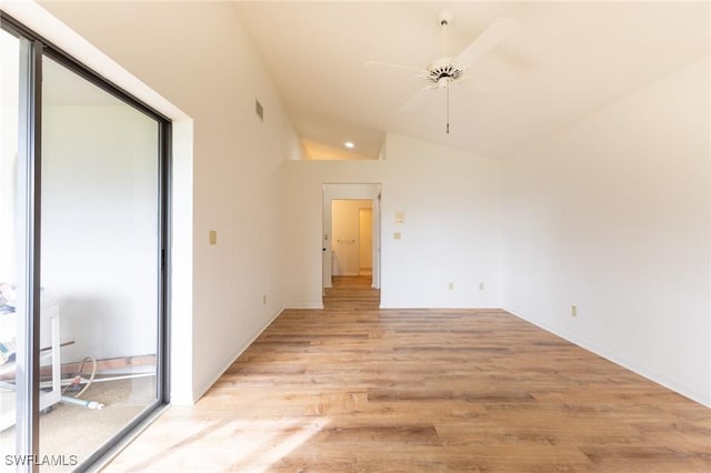 spare room with ceiling fan, vaulted ceiling, and light wood-type flooring