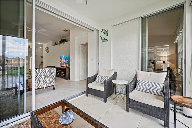 sunroom / solarium featuring ceiling fan