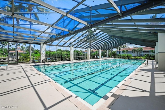 view of swimming pool with a patio and glass enclosure