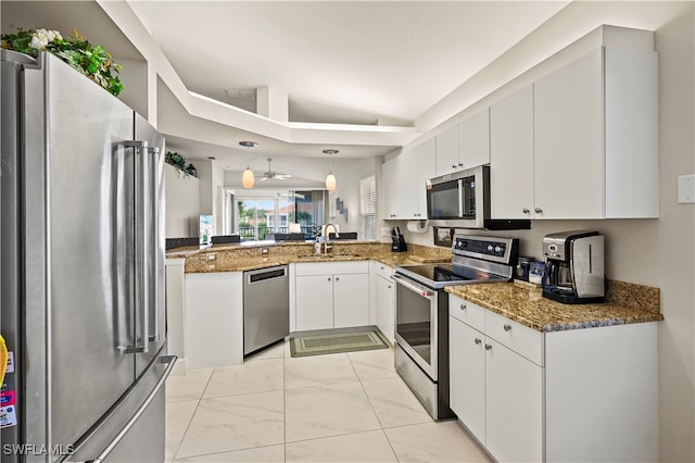 kitchen with hanging light fixtures, appliances with stainless steel finishes, sink, and white cabinetry