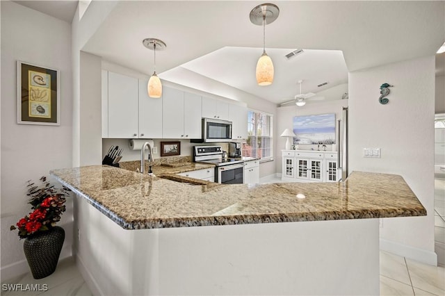 kitchen with white cabinets, appliances with stainless steel finishes, decorative light fixtures, and kitchen peninsula