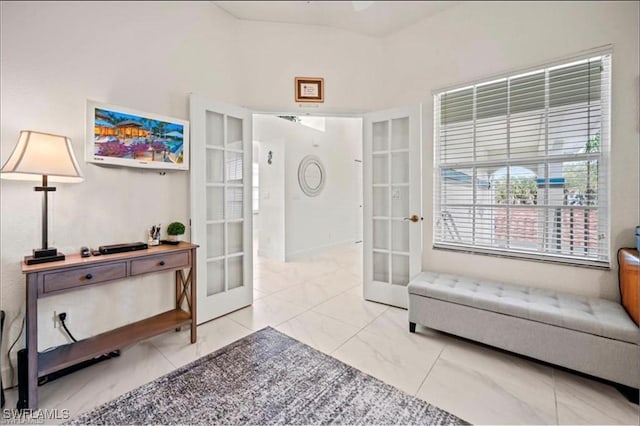 sitting room featuring french doors and built in shelves