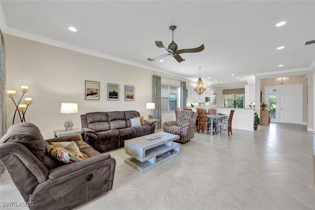 living room with crown molding, ceiling fan with notable chandelier, and light tile patterned floors