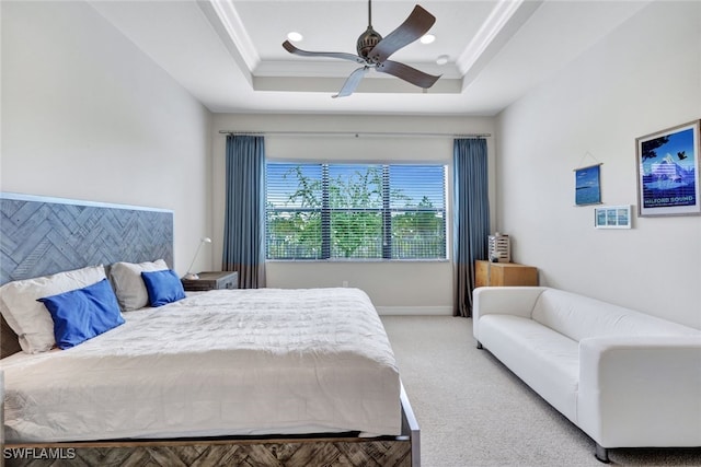 carpeted bedroom featuring ceiling fan, a raised ceiling, and crown molding