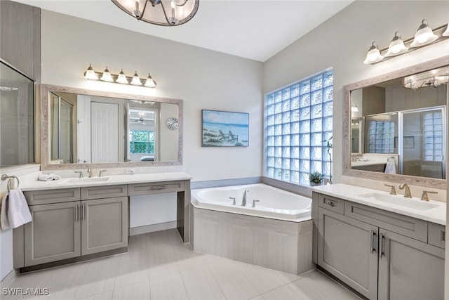 bathroom with a healthy amount of sunlight, vanity, and an inviting chandelier