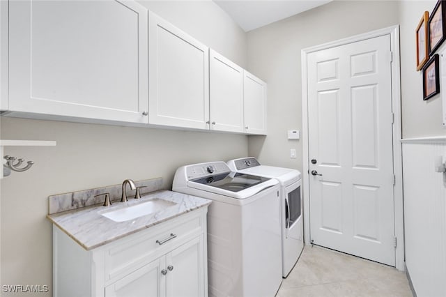 washroom featuring cabinets, sink, independent washer and dryer, and light tile patterned flooring