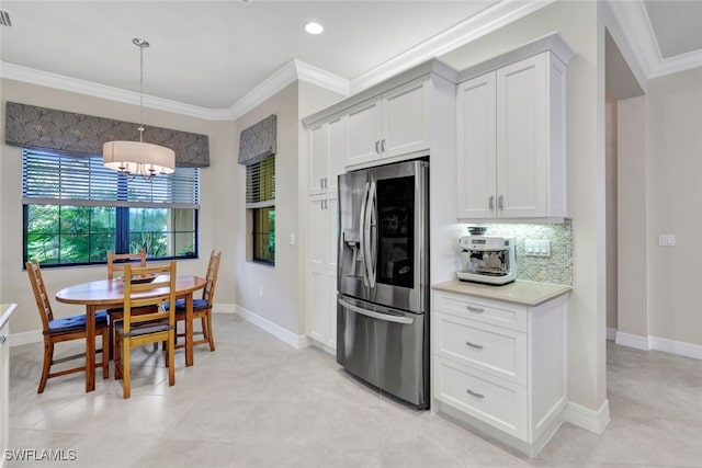 kitchen featuring stainless steel fridge, ornamental molding, an inviting chandelier, and pendant lighting