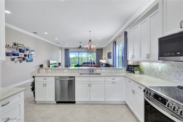 kitchen with ornamental molding, sink, kitchen peninsula, a chandelier, and appliances with stainless steel finishes