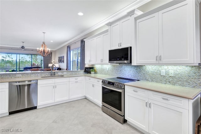 kitchen featuring decorative light fixtures, appliances with stainless steel finishes, crown molding, and white cabinetry